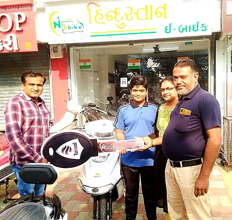 A family collecting a new electric scooter outside the Hindustan E-Bike shopfront