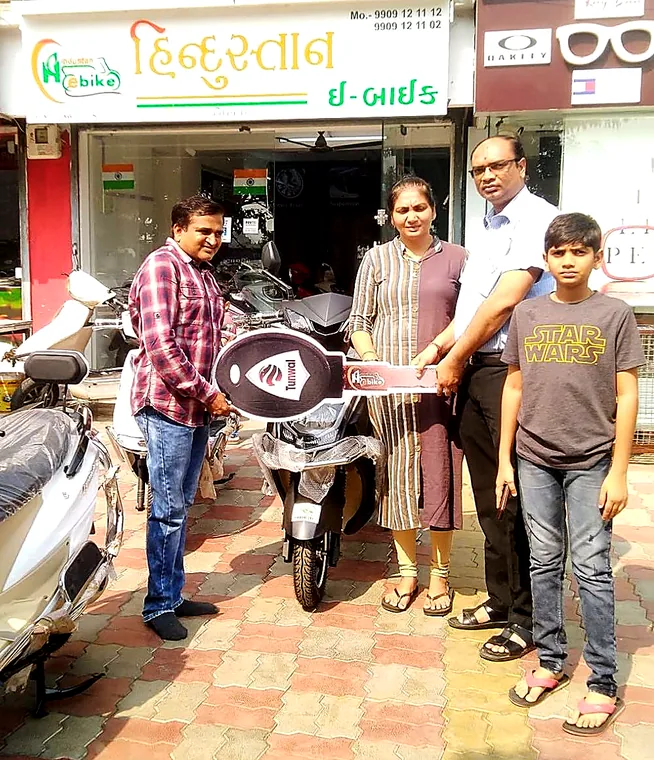 A family of four collecting their new electric scooter from the showroom